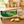 A package of Lobels Lemon Creams biscuits sits on a wooden table next to a cup of tea and several round biscuits, with a softly blurred kitchen background.